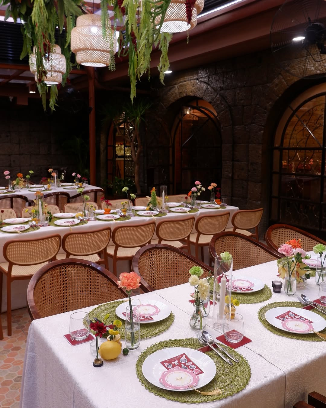 AMBAI main dining hall with stone arches, rattan chairs, and hanging lanterns